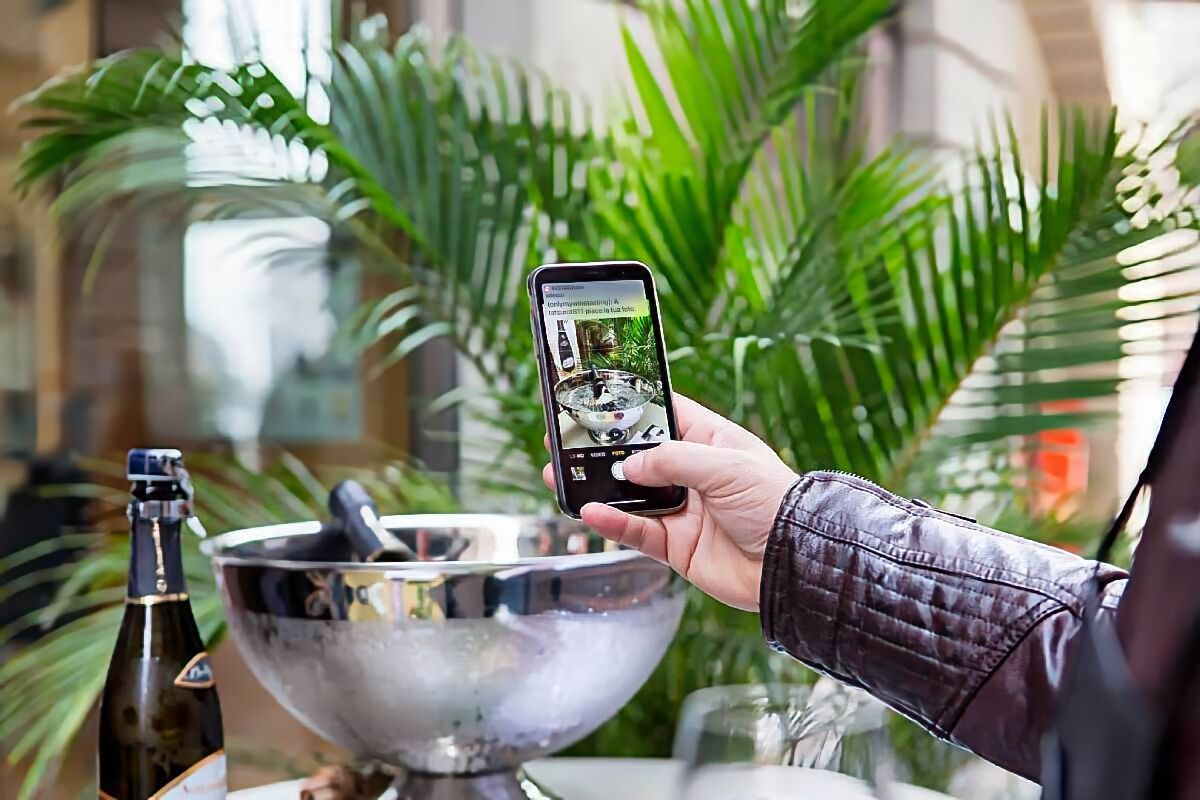 Degustazione di Pinot Nero Oltrepò Pavese: winelover fotografa bottiglie di spumante in secchiello a Voghera