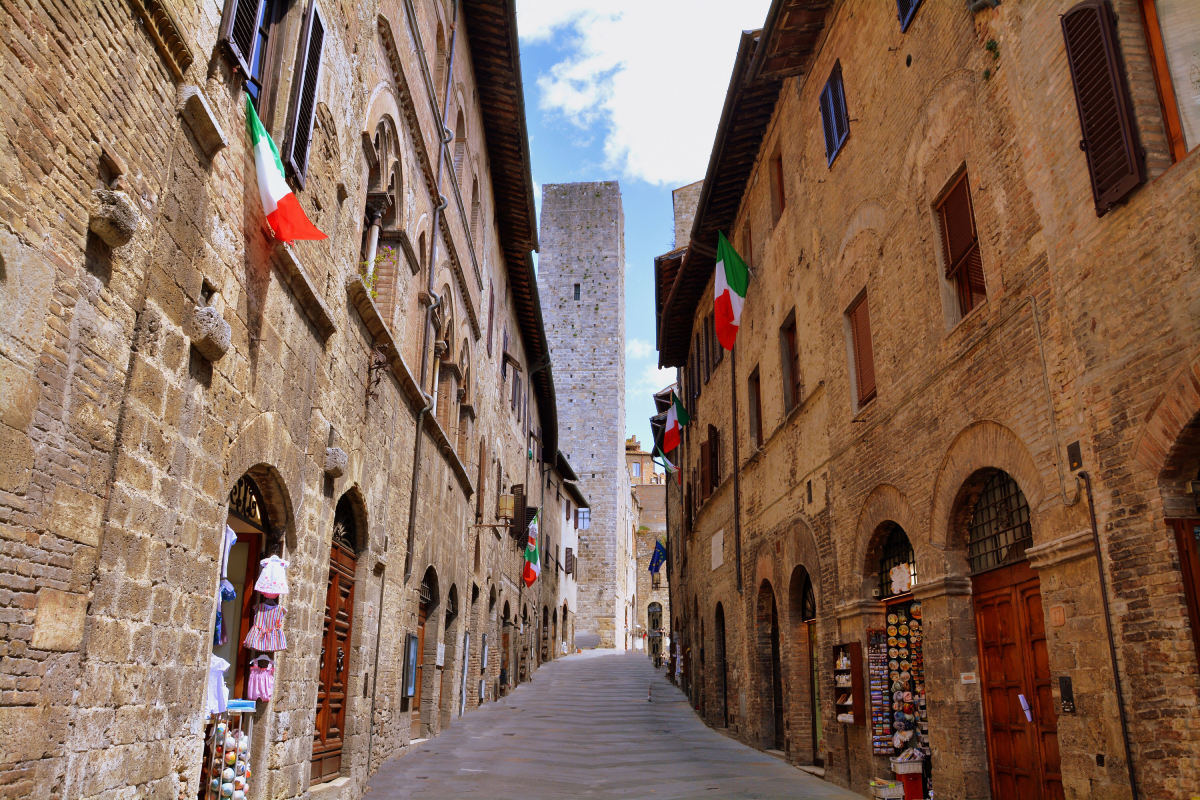 Strada medievale di San Gimignano con torri e case in pietra, Toscana